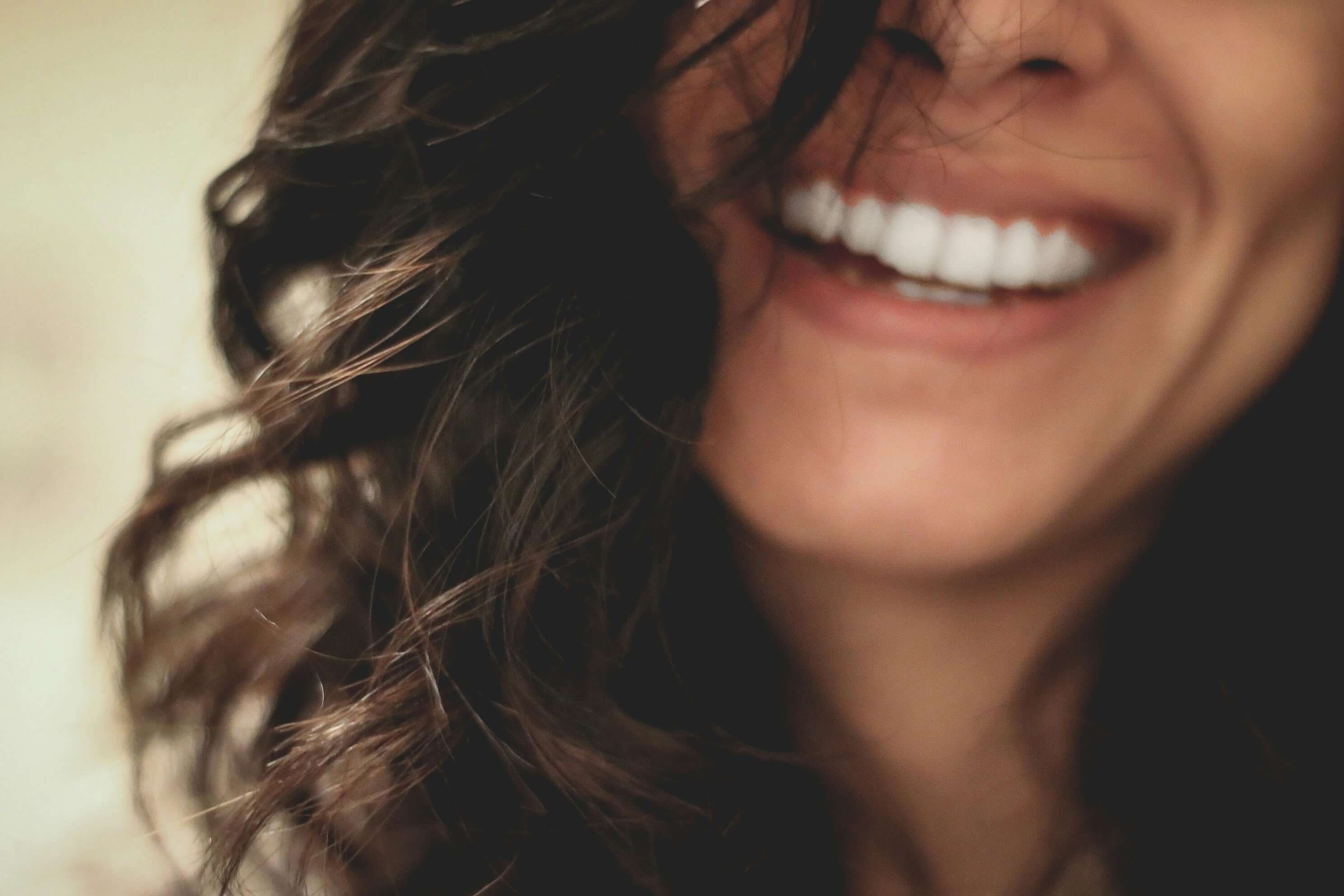 Close-up of a woman smiling with wavy hair