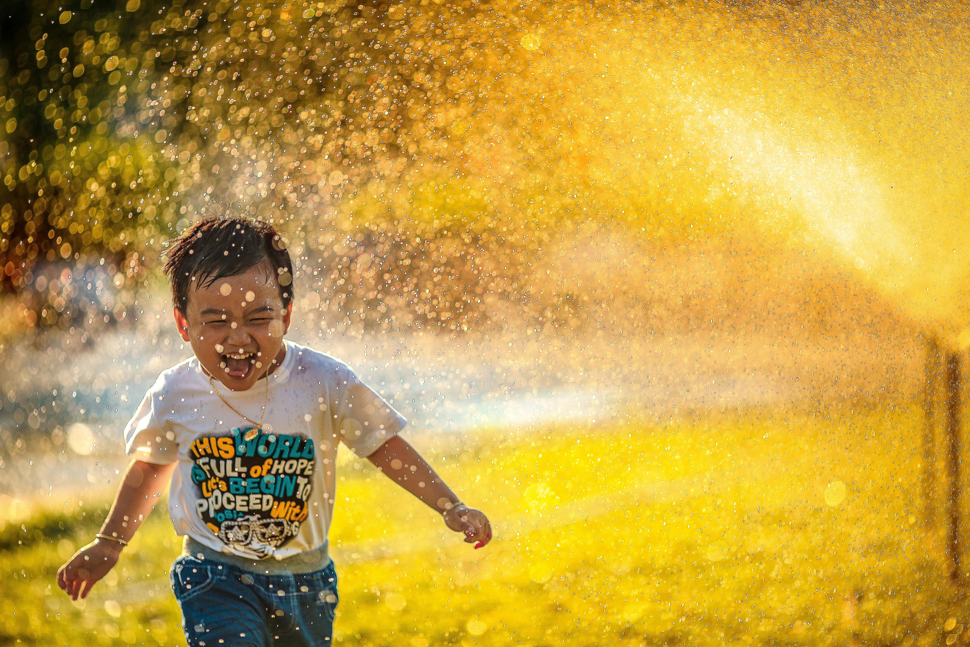 Child playing with a sprinkler in a grassy area